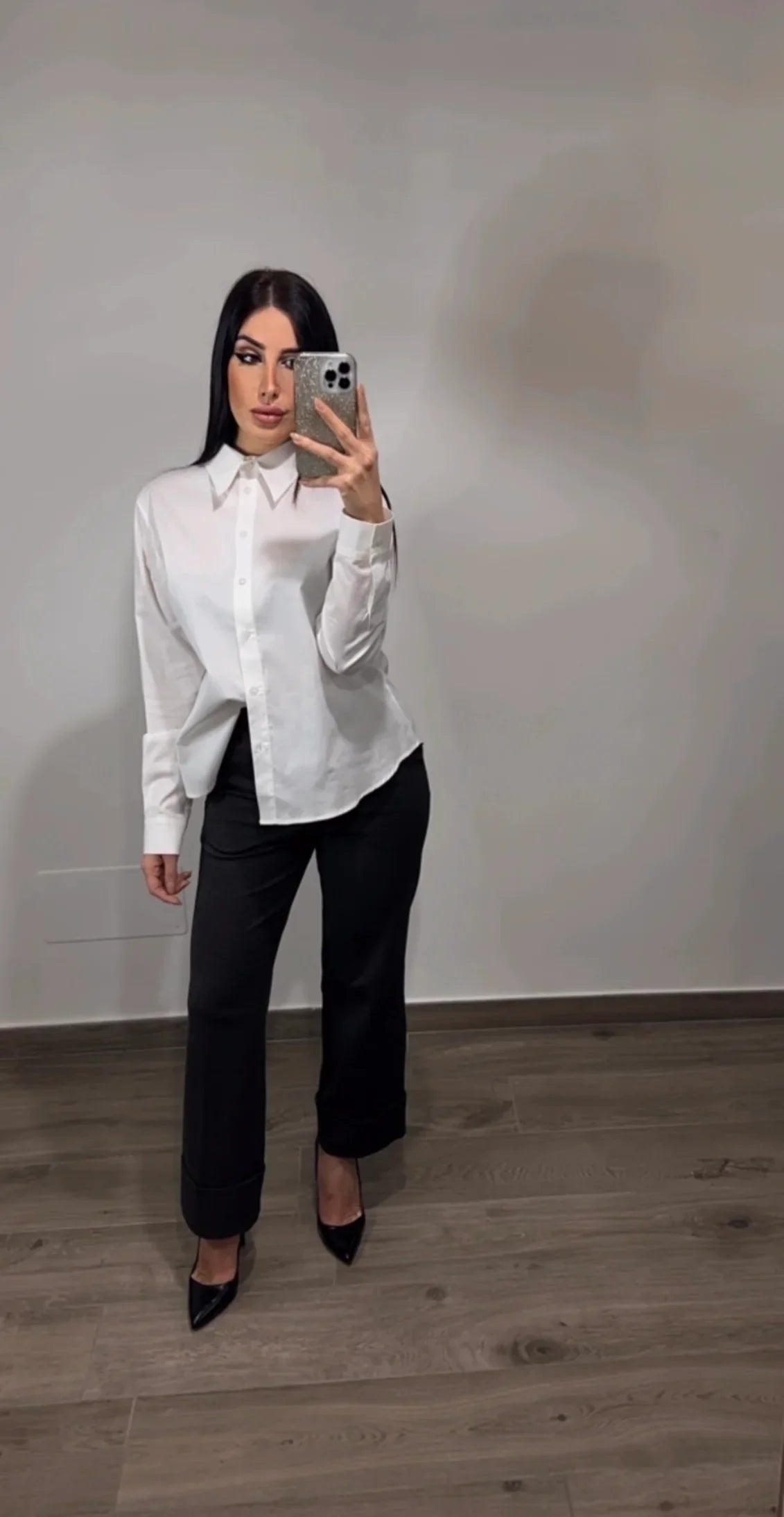Donna con camicia bianca e pantaloni neri eleganti, selfie allo specchio