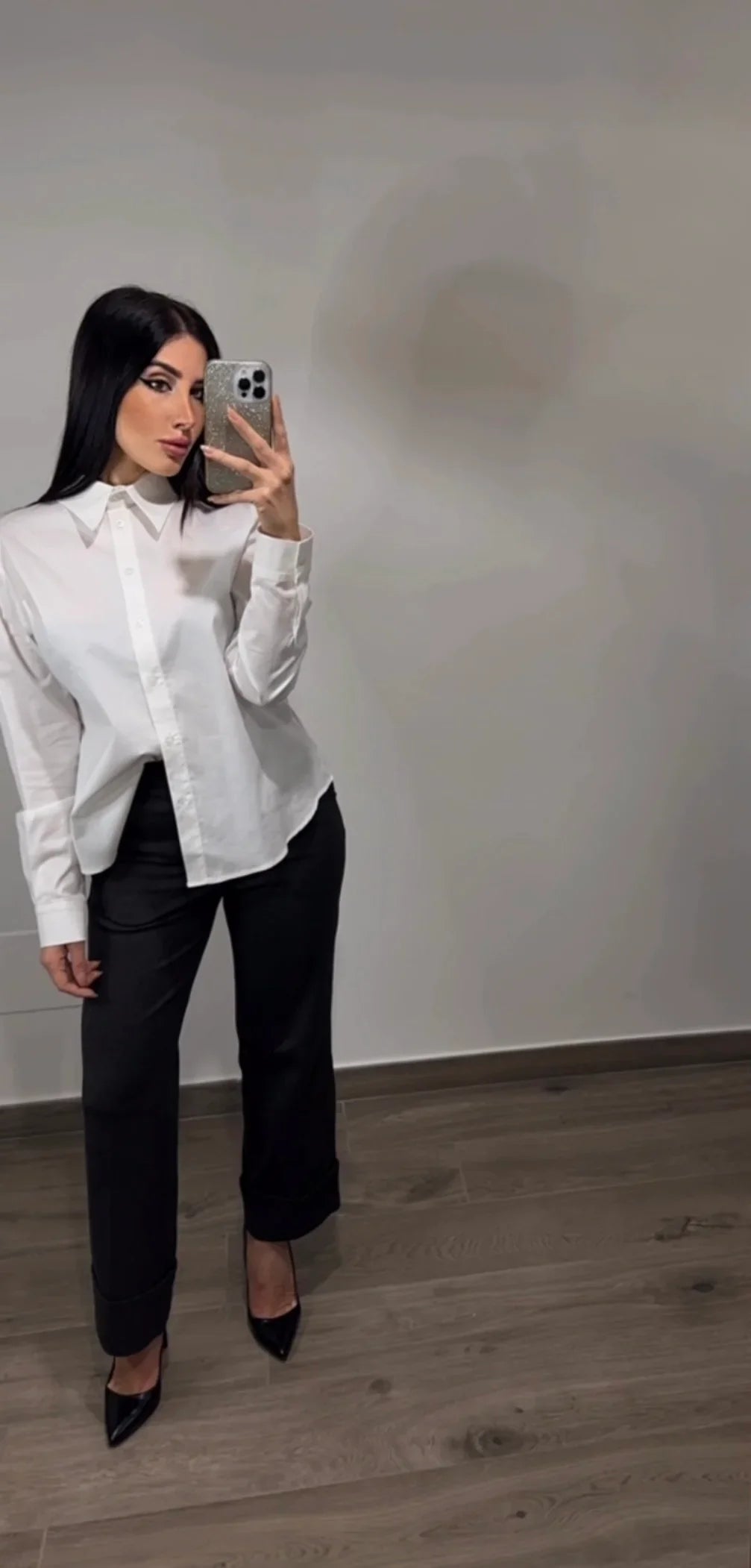 Donna con camicia bianca elegante e pantaloni neri, stile minimal chic, selfie allo specchio